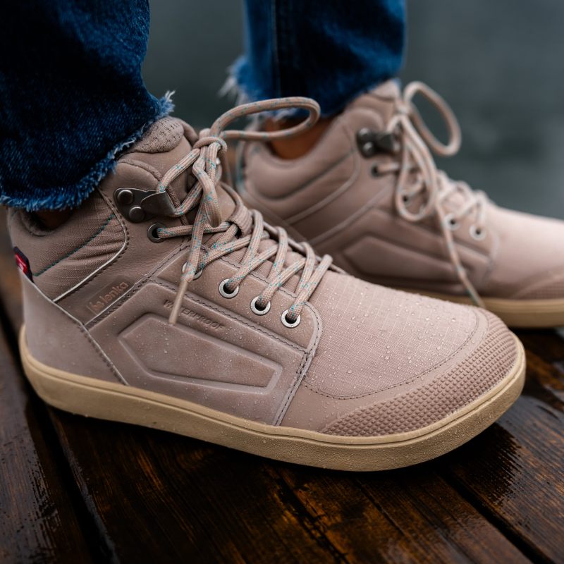 Beige winter barefoot shoes on a wet wooden surface
