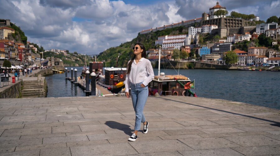 Mujer con zapatos barefoot caminando por el paseo fluvial de una ciudad histórica