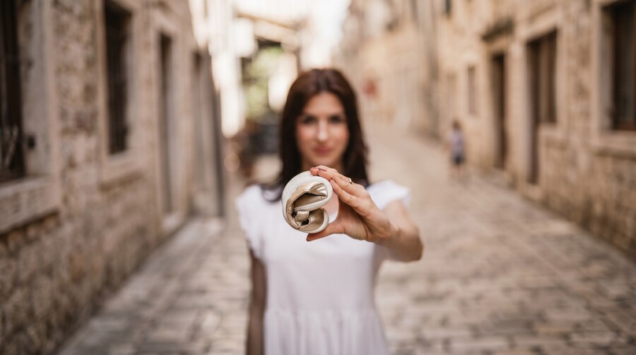 Mujer sosteniendo un zapato barefoot flexible enrollado para mostrar su flexibilidad