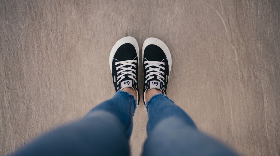 Vista cenital de pies con zapatos barefoot sobre una superficie sólida