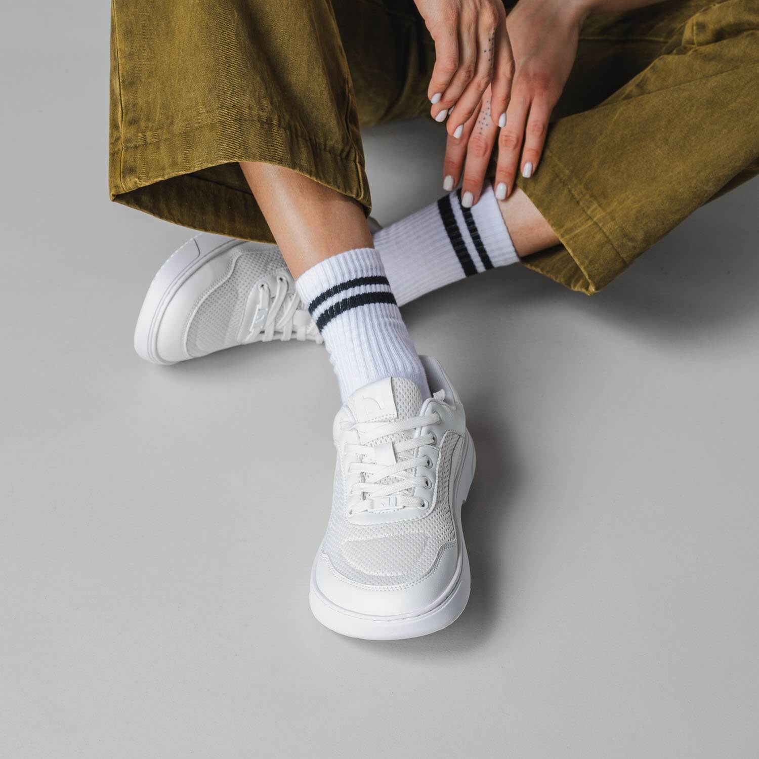 White mesh sneakers with striped crew socks