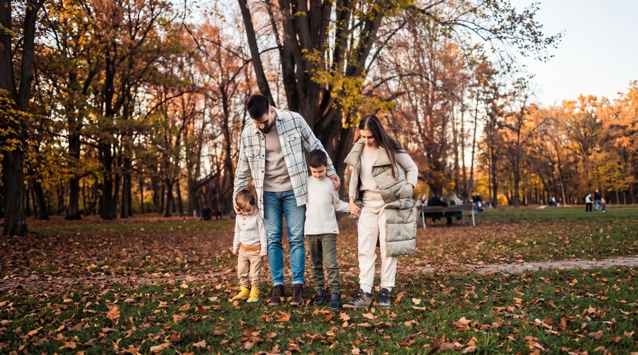Family in barefoot sneakers on a walk in an autumn park