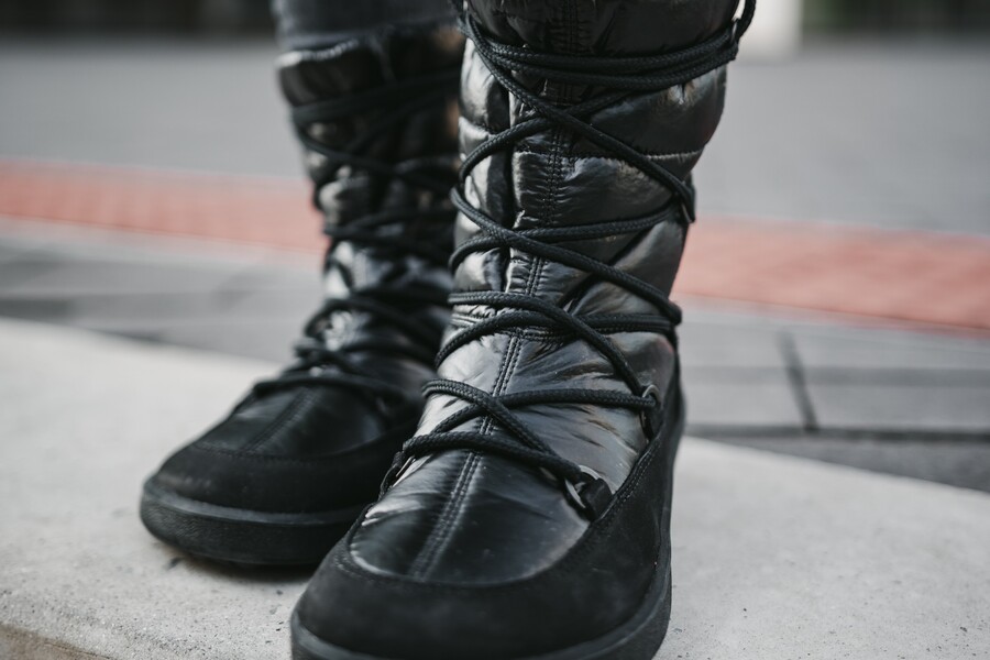Close-up of black laced barefoot snow boots in a wintry city Close-up of black laced barefoot snow boots in a wintry city