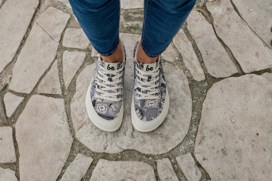 Widok z góry na stopy we wzorzystym damskim obuwiu barefoot na kamiennym bruku Widok z góry na stopy we wzorzystym damskim obuwiu barefoot na kamiennym bruku