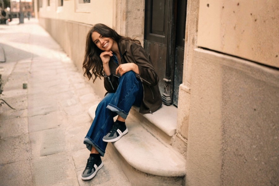 Woman in grey and black women's Barebarics sneakers sitting on a step in an alley Woman in grey and black women's Barebarics sneakers sitting on a step in an alley