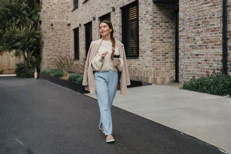Woman in beige women's office barefoot shoes walking down a city street