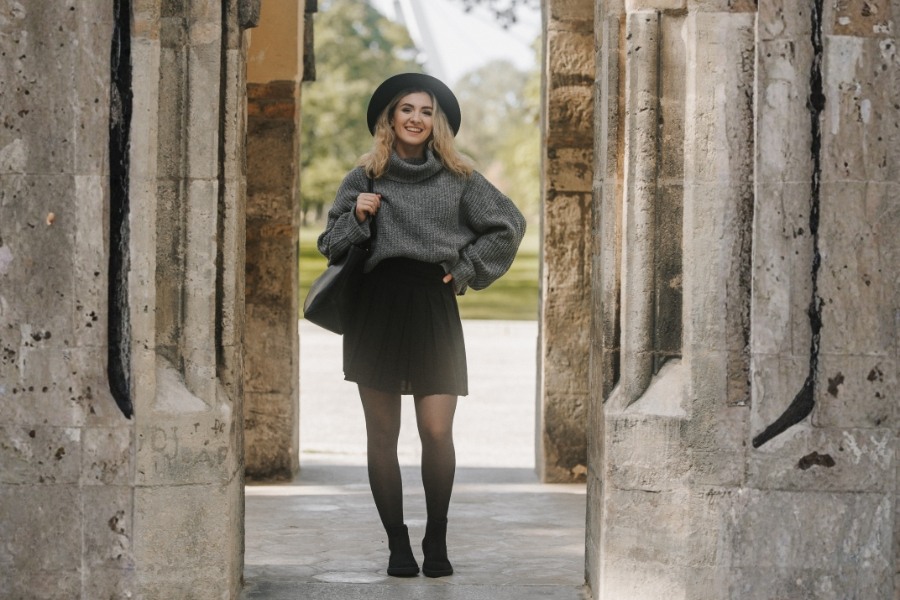 Woman in black women's ankle barefoot boots standing between stone columns Woman in black women's ankle barefoot boots standing between stone columns