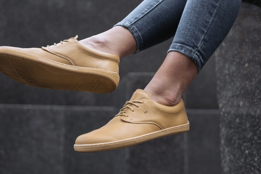 Close-up of feet in beige leather women's low barefoot shoes Close-up of feet in beige leather women's low barefoot shoes