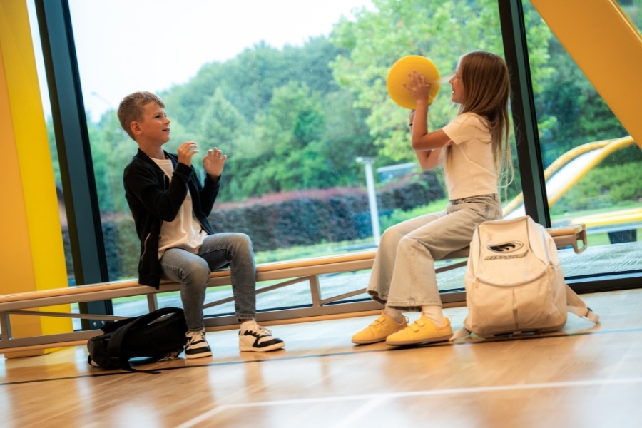 Deux enfants en chaussures barefoot pour enfants jouant au ballon près d'une grande fenêtre Deux enfants en chaussures barefoot pour enfants jouant au ballon près d'une grande fenêtre