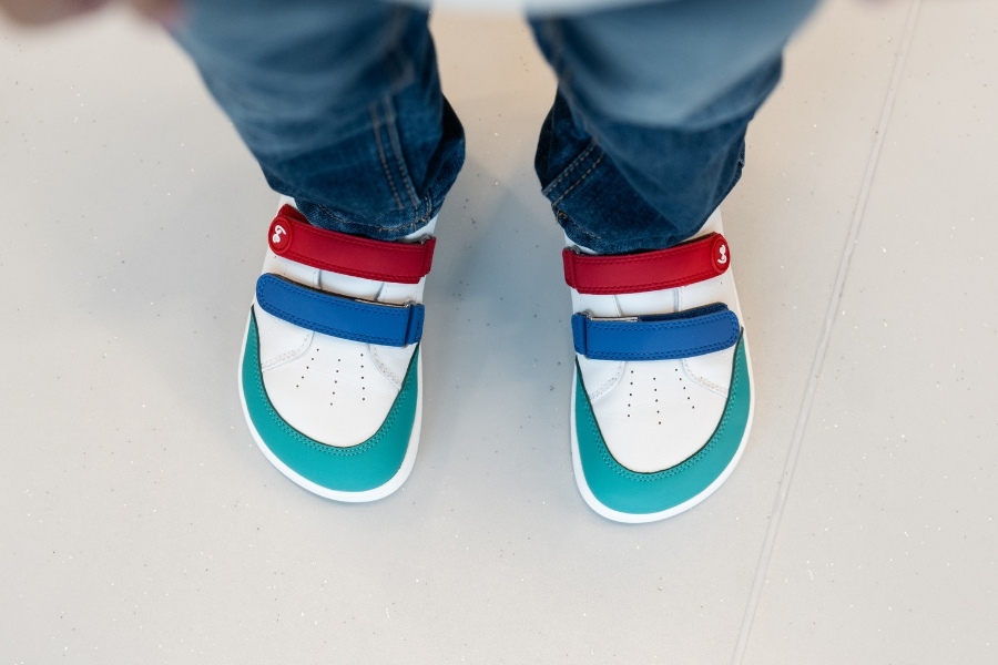 Gros plan de pieds d'enfant en chaussures barefoot colorées à scratch Gros plan de pieds d'enfant en chaussures barefoot colorées à scratch