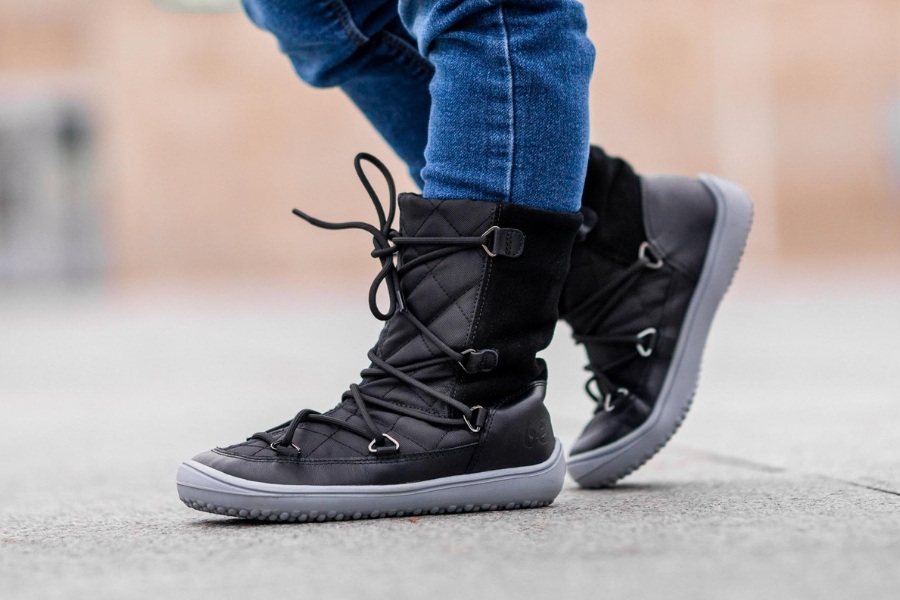 Close-up of a child's feet in black high winter barefoot shoes with lacing Close-up of a child's feet in black high winter barefoot shoes with lacing