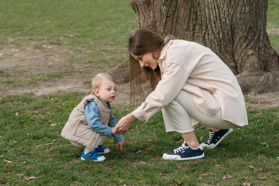 Erwachsene Person und Kleinkind im Frühlingspark, beide in den beliebtesten Barefoot Schuhen von Be Lenka.