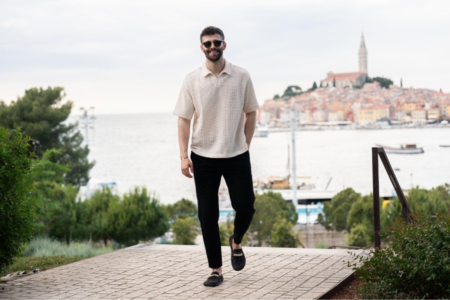 Homme en chaussures barefoot pour homme noires marchant sur un pavage au-dessus d'une ville côtière Homme en chaussures barefoot pour homme noires marchant sur un pavage au-dessus d'une ville côtière