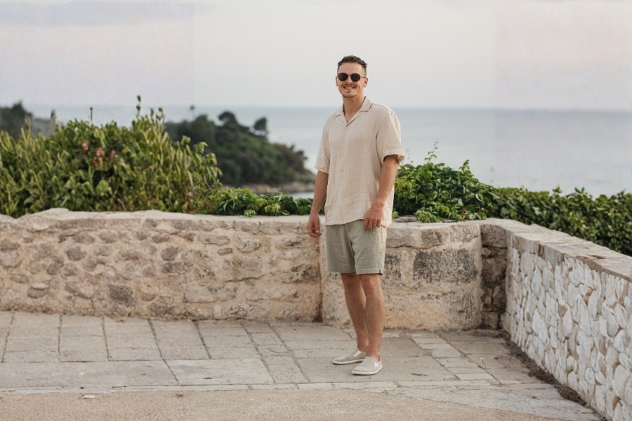 Man in cream men's slip-on barefoot shoes standing on a terrace by the sea Man in cream men's slip-on barefoot shoes standing on a terrace by the sea