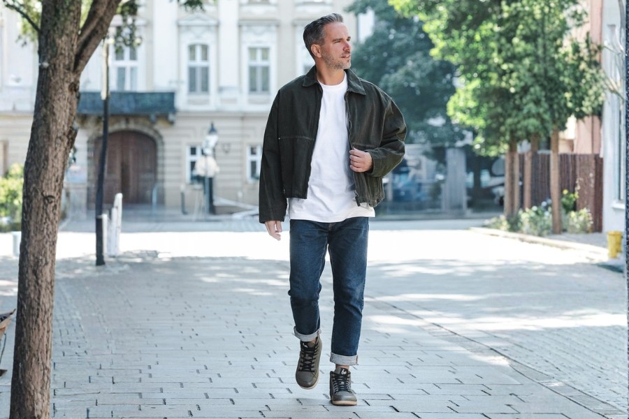 Man in khaki men's autumn barefoot shoes walking on a city pavement Man in khaki men's autumn barefoot shoes walking on a city pavement