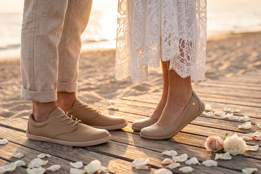 A couple standing on a wooden pier by the sea in beige barefoot wedding shoes among rose petals. A couple standing on a wooden pier by the sea in beige barefoot wedding shoes among rose petals.