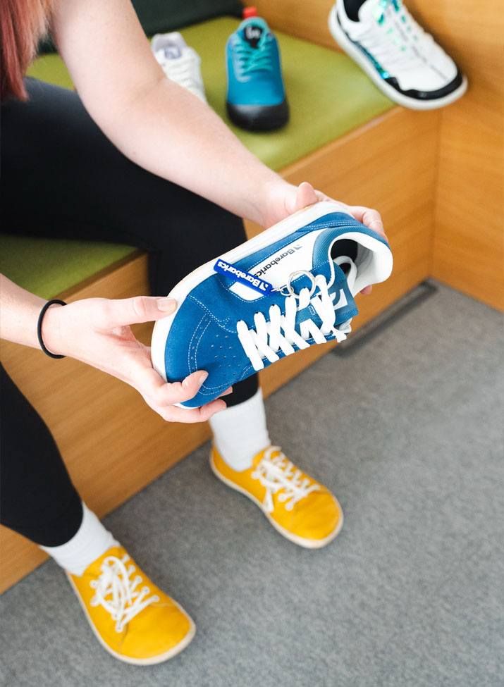 Dr. Jen Perez holding blue Barebarics sneakers