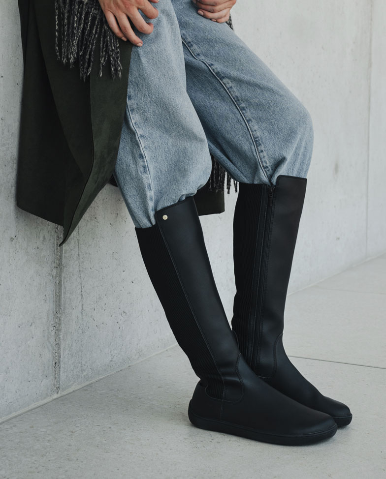 Be Lenka Symphony - Black, botas altas barefoot, modelo apoyada en la pared